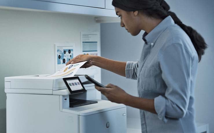 Kvinde dobbelttjekker sit print ved kontorprinter