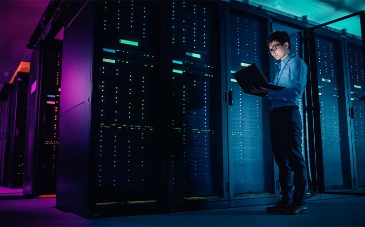 Mand står ved server rack