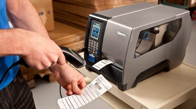 Kablet håndscanner på bord med etiket- og labelprinter